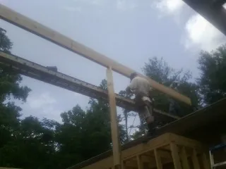 Carpenter setting a ridge beam over a new addition frame — Ice Dam Removal by Roofing Brothers in East Hickory