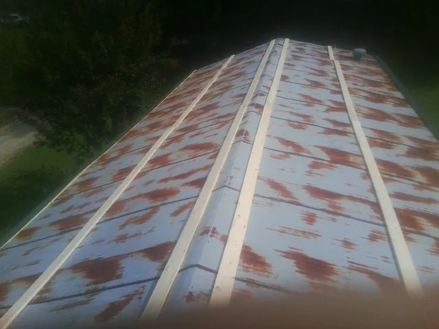 Rusted metal roof panels with new wood purlins before replacement — Storm Damage Roof Repair in East Hickory by Roofing Brothers