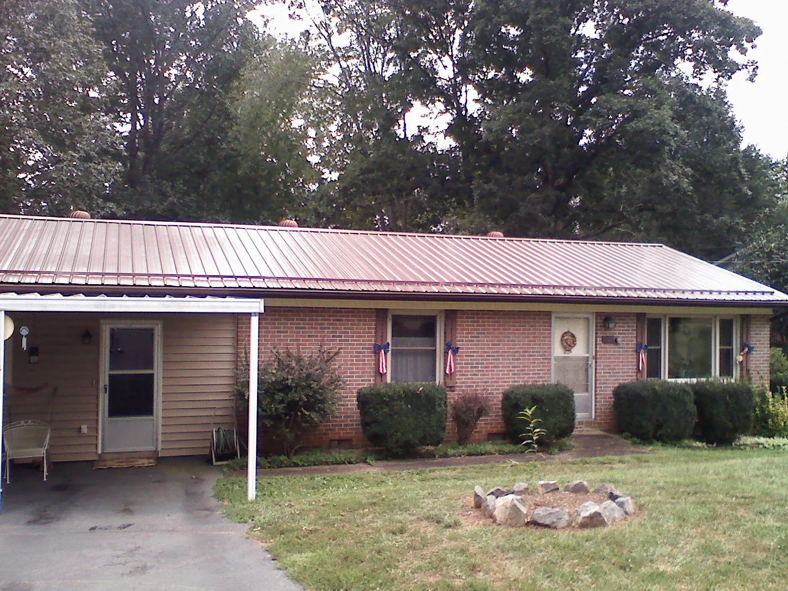 Bronze metal roof and carport on a brick ranch home — Roof Repair work by our crew in East Hickory